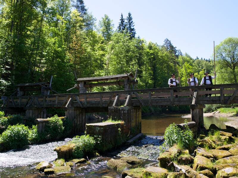 Flößer posieren bei blauem Himmel auf der Monhardter Wasserstube.