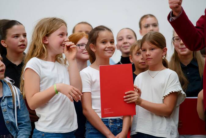 Kinder auf der Bühne des Bürgersaals freuen sich über ihre Urkunden.