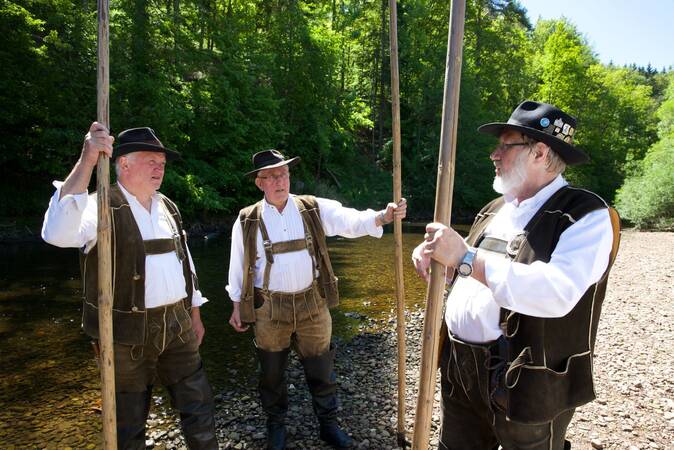 Drei Flößer unterhalten sich an der Nagold.